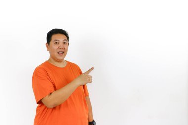 Şaşırmış, ağzı açık Asyalı bir adam sağ işaret parmağını boş fotokopi alanına doğru gösteriyor ve heyecanlı bir şekilde önemli bir şey gösteriyor..