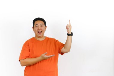 40 'lı yaşlarda turuncu bir tişört giyen yakışıklı bir erkek manken. Sağ taraftaki büyük beyaz boşluğu işaret ediyor. Mesajınız ya da logonuz için mükemmel..