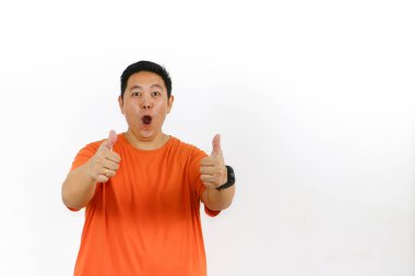 Şaşırmış, ağzı açık Asyalı bir adam iki eliyle iki coşkulu baş parmak hareketi yapıyor. Heyecan, onay ve tam bir uzlaşma..