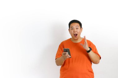 Turuncu tişörtlü, akıllı telefonlu, ağzı açık Asyalı bir adam el kaldırdı ve şok etkisi yarattı..