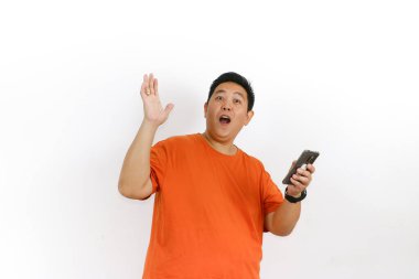 Turuncu tişörtlü, akıllı telefonlu, ağzı açık Asyalı bir adam el kaldırdı ve şok etkisi yarattı..