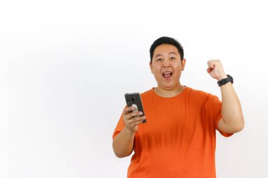 Cep telefonunu kullanan mutlu Endonezyalı bir erkek modelin portresi ve beyaz arka planda izole edilmiş kazanan bir jest..