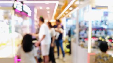 Işıl ışıl ışıkları olan kalabalık eğlence merkezinin bulanık arka planı ve pençe makinelerinden ödül kazanmaya çalışan insanlar..