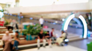 Ailesiyle yürüyen ve perakende satış mağazasının ışıklarını dağıtan insanların olduğu soyut alışveriş merkezi sahnesi.