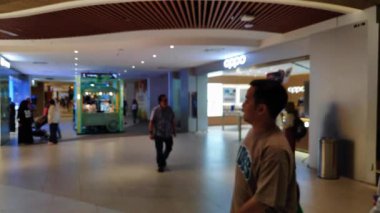 Ailesiyle yürüyen ve perakende satış mağazasının ışıklarını dağıtan insanların olduğu soyut alışveriş merkezi sahnesi.