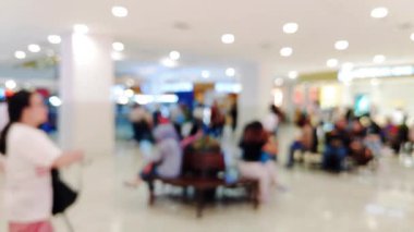 Ailesiyle yürüyen ve perakende satış mağazasının ışıklarını dağıtan insanların olduğu soyut alışveriş merkezi sahnesi.