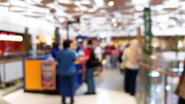 Mutlu hafta sonu aktiviteleri, şehir hayatı konsepti için odaklı olmayan bir mimariyle alışveriş merkezinde yürüyen insanları bulanık gösteriyor..