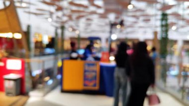 Mutlu hafta sonu aktiviteleri, şehir hayatı konsepti için odaklı olmayan bir mimariyle alışveriş merkezinde yürüyen insanları bulanık gösteriyor..