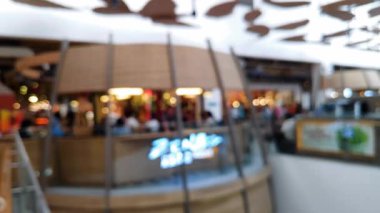 Akrabalarıyla yürüyen ve reklam projesi için ışık saçan insanların bulanıklığını gösteren yoğun bir mağaza.