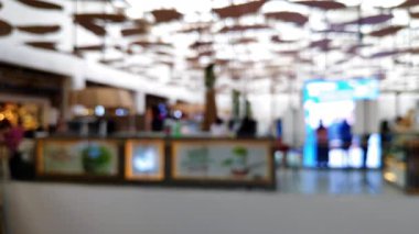 Akrabalarıyla yürüyen ve reklam projesi için ışık saçan insanların bulanıklığını gösteren yoğun bir mağaza.