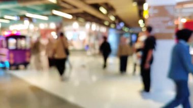Mutlu hafta sonu aktiviteleri, şehir hayatı konsepti için odaklı olmayan bir mimariyle alışveriş merkezinde yürüyen insanları bulanık gösteriyor..
