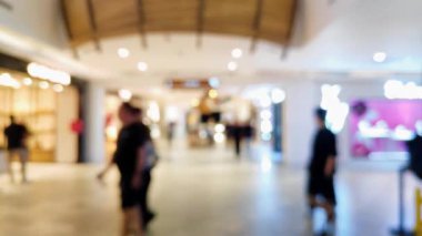 Akrabalarıyla yürüyen ve reklam projesi için ışık saçan insanların bulanıklığını gösteren yoğun bir mağaza.