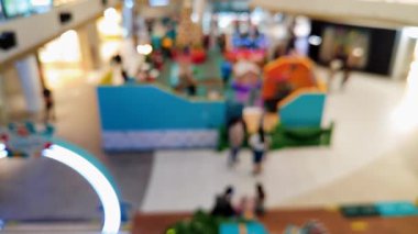 Akrabalarıyla yürüyen ve reklam projesi için ışık saçan insanların bulanıklığını gösteren yoğun bir mağaza.