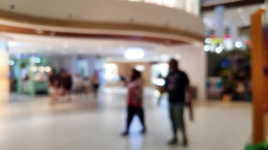 Ailesiyle gezen ve ticari kullanım için parlayan vitrinleri kapatan insanların bulanık görüntülerinin yer aldığı sinematik görüntüler.