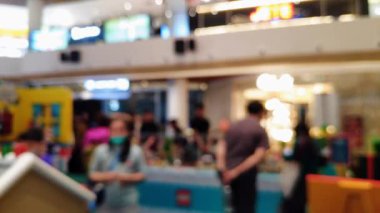 Ailesiyle gezen ve ticari kullanım için parlayan vitrinleri kapatan insanların bulanık görüntülerinin yer aldığı sinematik görüntüler.