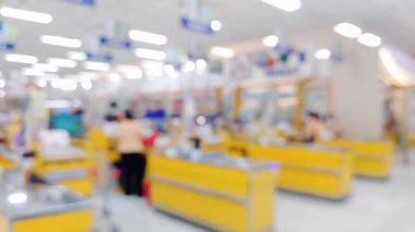 Alışveriş ortamı, modern tüketim teması için odaklanmış bokeh ile kasiyerdeki müşterilerin bulanıklığını gösteriyor