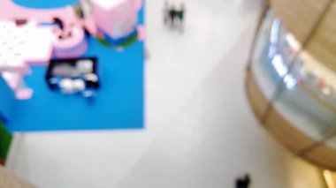 Arka plan için odaklanmış zemin desenleri ile alışveriş merkezinde yürüyen insanların bulanık görüntüsünü içeren soyut bir üst görünüm.