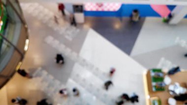 Arka plan için odaklanmış zemin desenleri ile alışveriş merkezinde yürüyen insanların bulanık görüntüsünü içeren soyut bir üst görünüm.