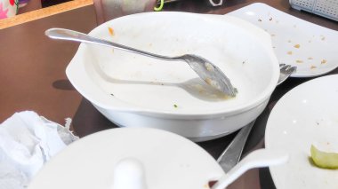 Akşam yemeğinden sonra dağınık boş tabakları yağlı ve temizlik konsepti için sürülmüş soslu gösteriyor..