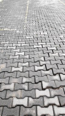 Sarı park çizgileri açıkça görülebilen birbirine kenetlenmiş gri beton kaldırımları kapat.