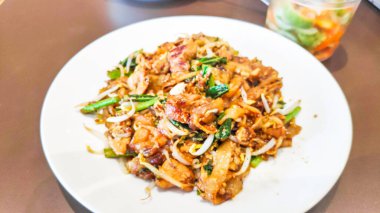 Otantik bir Güneydoğu Asya sokak yemeği olan Char Kway Teow 'a yakın. Yanında fasulye filizi, yumurta tavuklu karides..