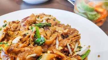 Otantik bir Güneydoğu Asya sokak yemeği olan Char Kway Teow 'a yakın. Yanında fasulye filizi, yumurta tavuklu karides..