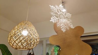 Büyük asılı zencefilli ekmek adam ve altın yıldız fener süslemesi bir kafede şenlikli bir Noel atmosferi yaratıyor..