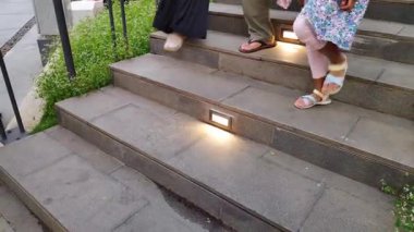 Kalabalık bir alışveriş merkezinin parlak seramik zemininde yürüyor..