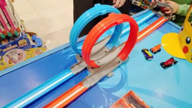 Oyuncak arabaları fırlatırken çocukların elleri ve yüzleri heyecanlanıyor.