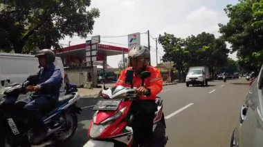 Şehir merkezinde yoğun bir öğleden sonra trafiğinde motosikletli ve arabalı yolcular var. Bandung, Endonezya 9 Ocak 2026