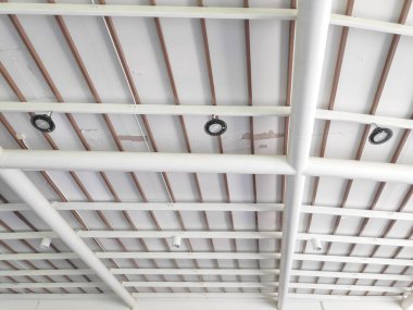 İhmal edilmiş bir binanın iç kısmındaki çatlamış tavanı kahverengi levhalarla kapatın.