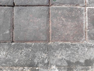 Gerçekçi kullanım işaretleri ve kir olan ağır beton karolardan yapılmış yaya kaldırımının yüksek açılı görüntüsü.