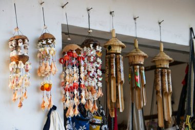 El boyaması bambu rüzgâr çanları 1 Haziran 2025 'te bir Bali hediyelik eşya dükkanında peş peşe asılıyor.