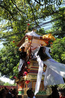 Balili adamlar, Denpasar Bali 'de 1 Haziran 2025' te yakma ayini için uzun bir cenaze kulesi taşıyorlar.