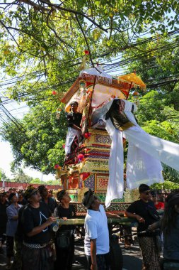 Balili adamlar, Denpasar Bali 'de 1 Haziran 2025' te yakma ayini için uzun bir cenaze kulesi taşıyorlar.