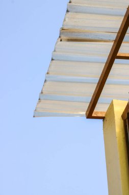 Translucent corrugated canopy roof against a clear blue sky