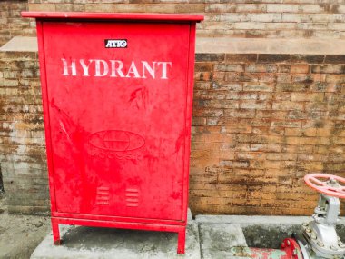 Kırmızı bir açık hava yangın musluğu geleneksel bir Bali kırmızı tuğla duvarına karşı duruyor Denpasar 7 Mayıs 2025