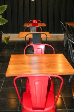 Canlı kırmızı bir kafeterya sandalyesi modern bir açık hava terasına renk katar.