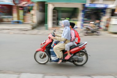 20 Ağustos 2025 'te Bandung, Endonezya' da bir ara sokakta kaskı takmayan bir motosikletçiye tehlikeli sürüş davranışı