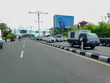 Denpasar şehri Bali, Endonezya 'da 17 Nisan 2025' te sakin trafiğin ortasında yürüyen yerel halk