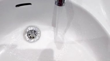 Krom musluktan dökülen kristal berrak su saflığı ve küresel su sürdürülebilirliğini temsil ediyor.