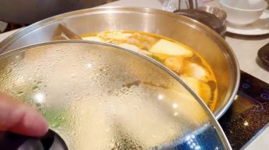 Geleneksel Japon sukiyaki köfteli ve sebzeli yavaş çekim otantik Tayland restoranında sıcak et suyunda kaynıyor.