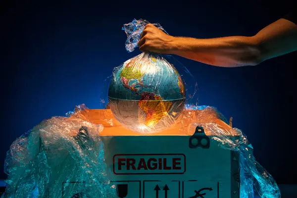 An employee takes a valuable cargo out of a wooden box, a concept for the delivery of a fragile or valuable cargo. A man takes out a globe or earth from a box. High quality photo