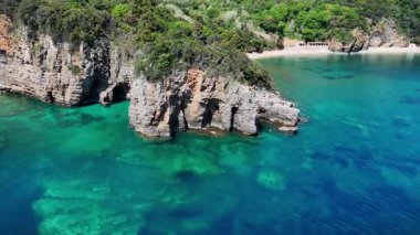 Bir deniz mağarası manzarası. Dağların panoramik manzarası ve bir dron tarafından yakalanan deniz. Güzel kayalıklar, sahil ve mavi göl.