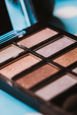 Mavi ahşap masada makyaj fırçası ve kozmetik ürünleri