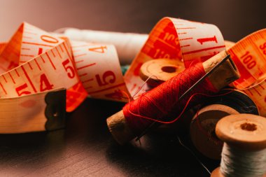 iş parçacığı yüksük ve ahşap arka plan üzerinde ölçüm bandı çok Vintage biriktirir