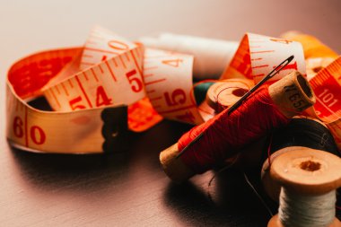 iş parçacığı yüksük ve ahşap arka plan üzerinde ölçüm bandı çok Vintage biriktirir