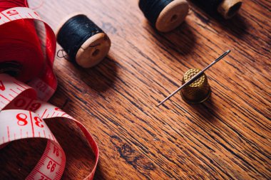 ahşap bir arka plan üzerinde ölçü uzunluk, makas, renkli iplik biriktiricileri aracına terzi