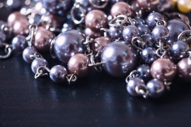 karanlık bir arka plan yansıması ile gri ve pembe inci kolye