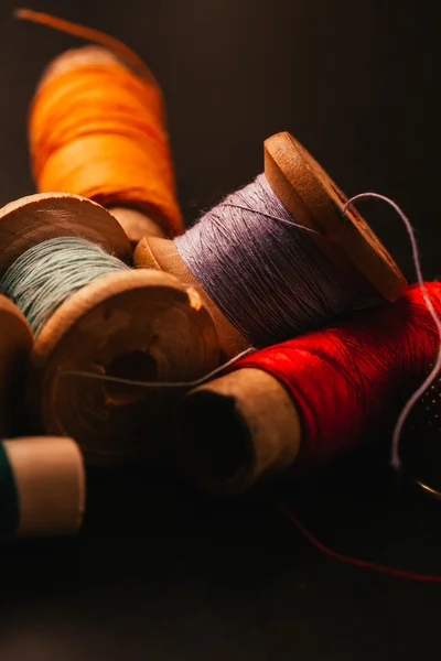 vintage reel of thread and thimble on a wooden background